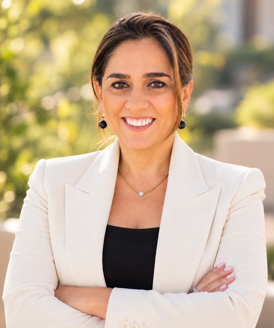 SKOPE founder Sherine Khalil in a light blazer with arms crossed, outdoors